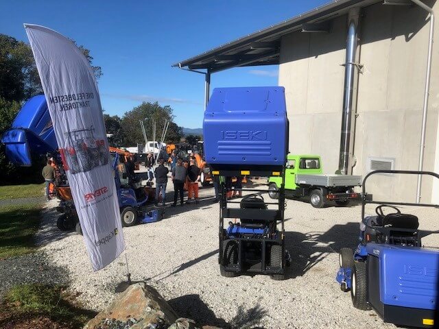 Gartenbaumaschinen-Ausstellung im Freien mit ISEKI-Geräten und Besuchern bei sonnigem Wetter.