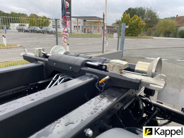 Hydraulisches System eines LKW-Aufbaus mit Nahaufnahme der Mechanik auf einem Parkplatz.