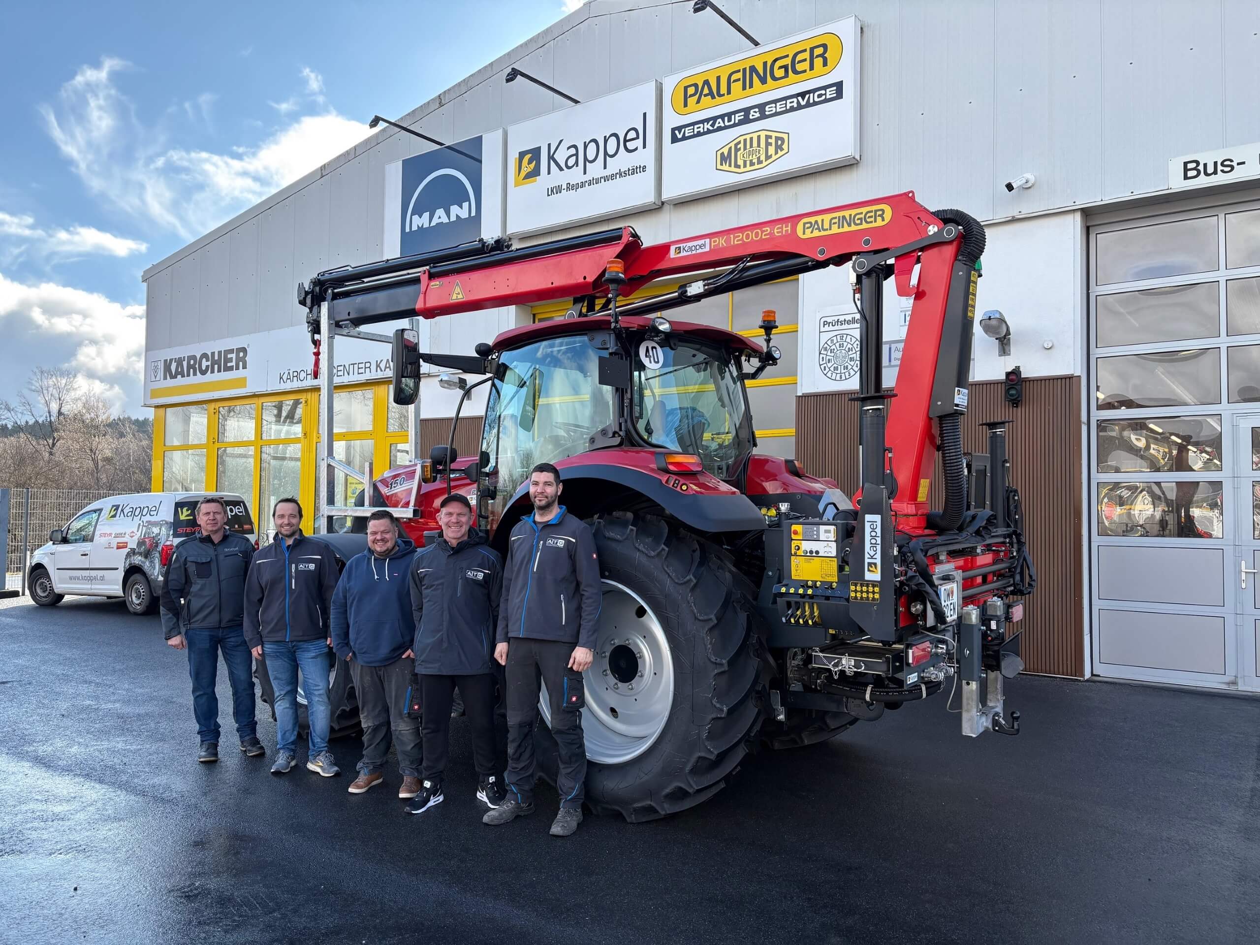 Mitarbeitergruppe vor Kappel-Werkstatt mit Palfinger-LKW, bereit für Fahrzeugservice bei strahlendem Himmel.